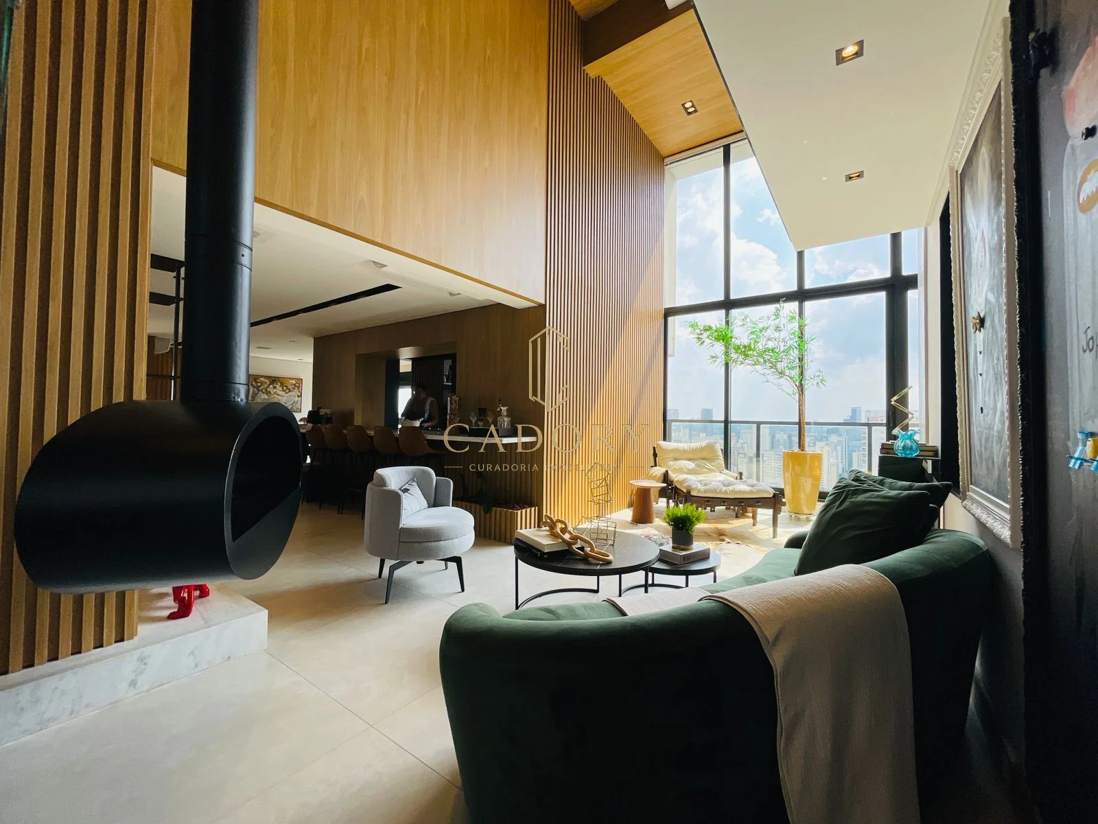 Sala de estar de pé-direito duplo, com lareira e vista para o pôr do sol